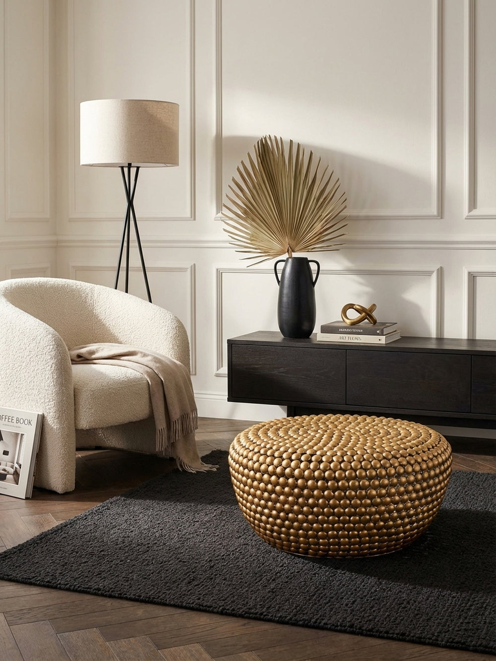 Designer Sofatisch aus Aluminium von oben gesehen, seine strukturierte goldene Oberfläche bildet einen spannenden Kontrast zum grafischen Teppich im Wohnbereich._