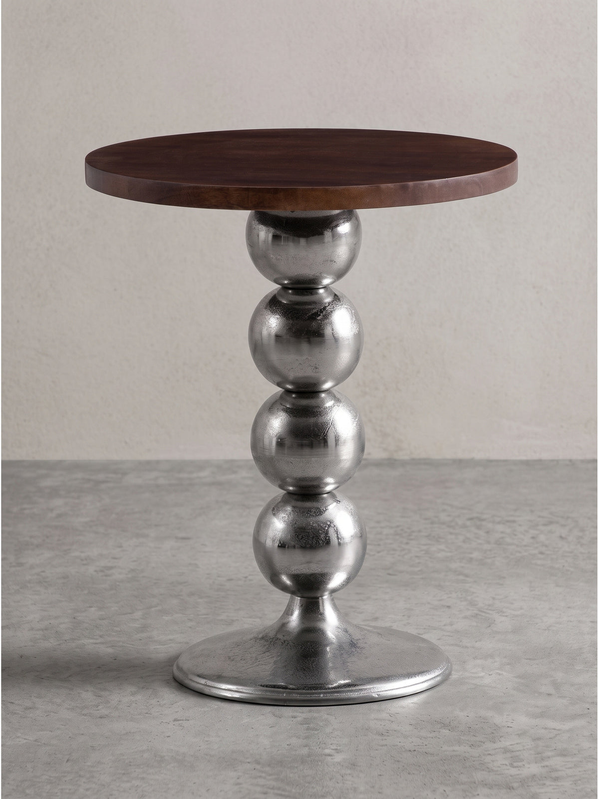 Vorderansicht des runden Beistelltischs aus Mango Massivholz mit markantem Kugel-Standbein aus silbernem Aluminium vor weißem Hintergrund.