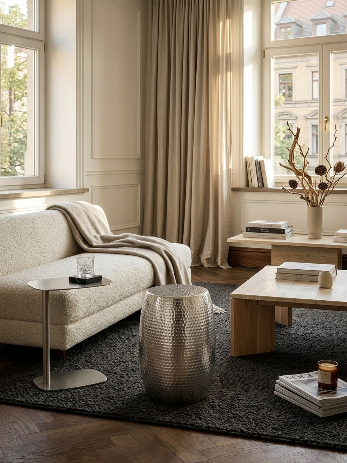 Draufsicht auf den kleinen Hammerschlag Dekotisch in Silber, 30x30cm runde Ablagefläche für Getränke oder Bücher neben einer Couch im luxuriösen Interieur.
