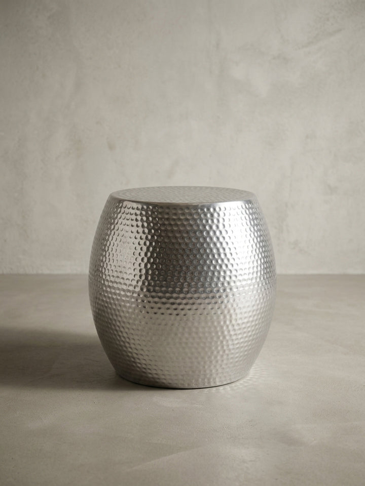 Alternative Perspektive des silbernen Hammerschlag Beistelltisches. Die leicht gewölbte Form des runden Aluminium Anstelltisches reflektiert das einfallende Licht elegant._