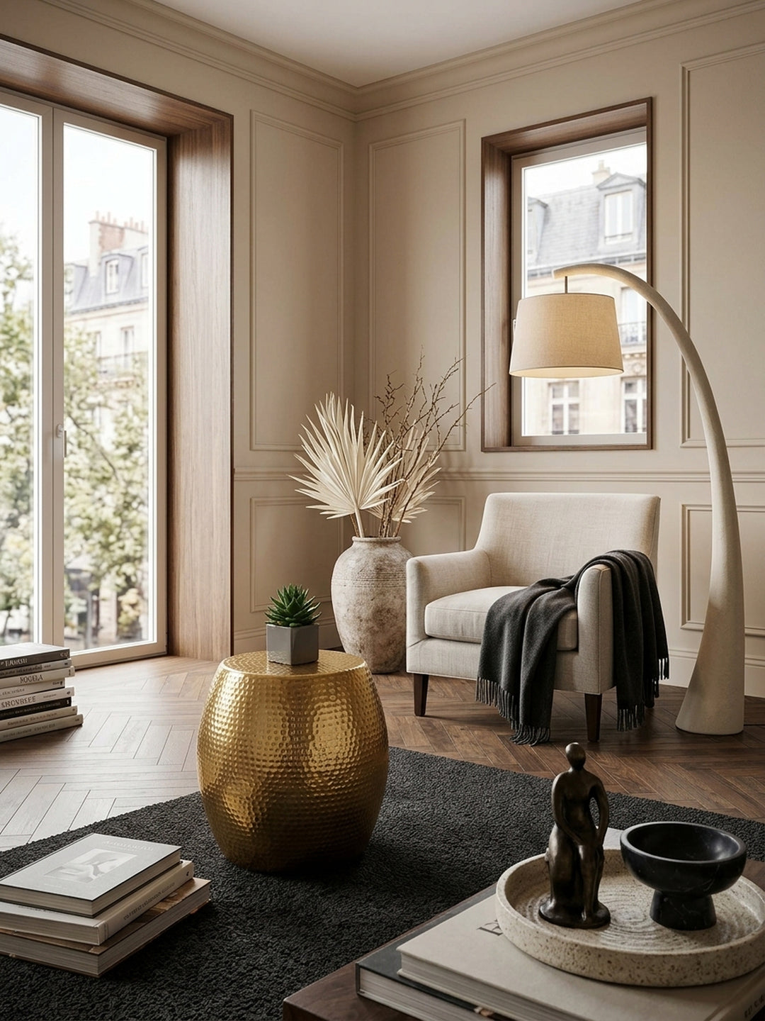 Draufsicht auf einen kompakten Designer-Dekotisch in Gold im modernen Lounge-Bereich. Der kleine Ablagetisch aus Metall harmoniert perfekt mit dem dunklen Bouclé-Teppich._