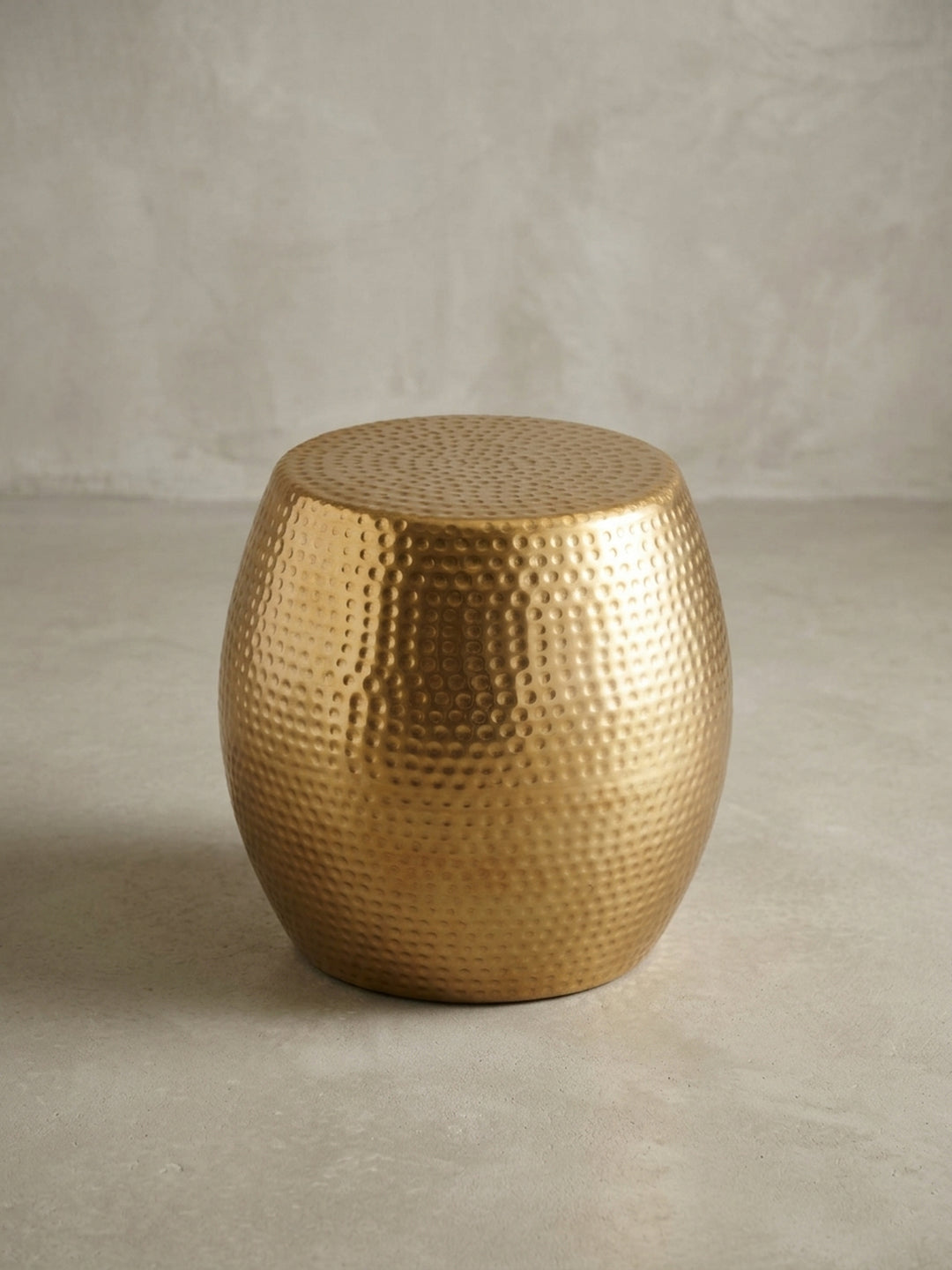 Alternative Perspektive des metallischen Designer-Ablagetisches in Gold. Die glänzende Beschichtung des Aluminiumtisches fängt das Umgebungslicht auf elegante Weise ein._