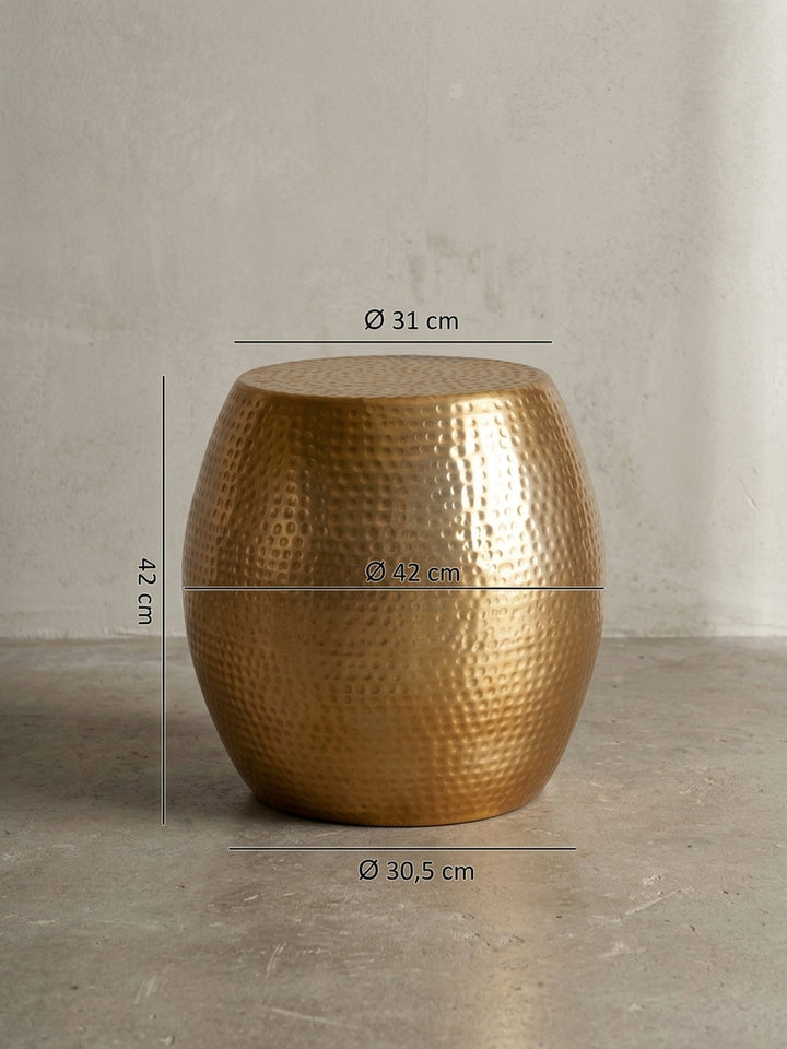 Detailansicht der nahtlosen Verarbeitung des runden goldenen Dekotisches. Der durchgehende Aluminium-Korpus mit Hammerschlag-Design steht stabil auf einer 30,5 cm breiten Basis._