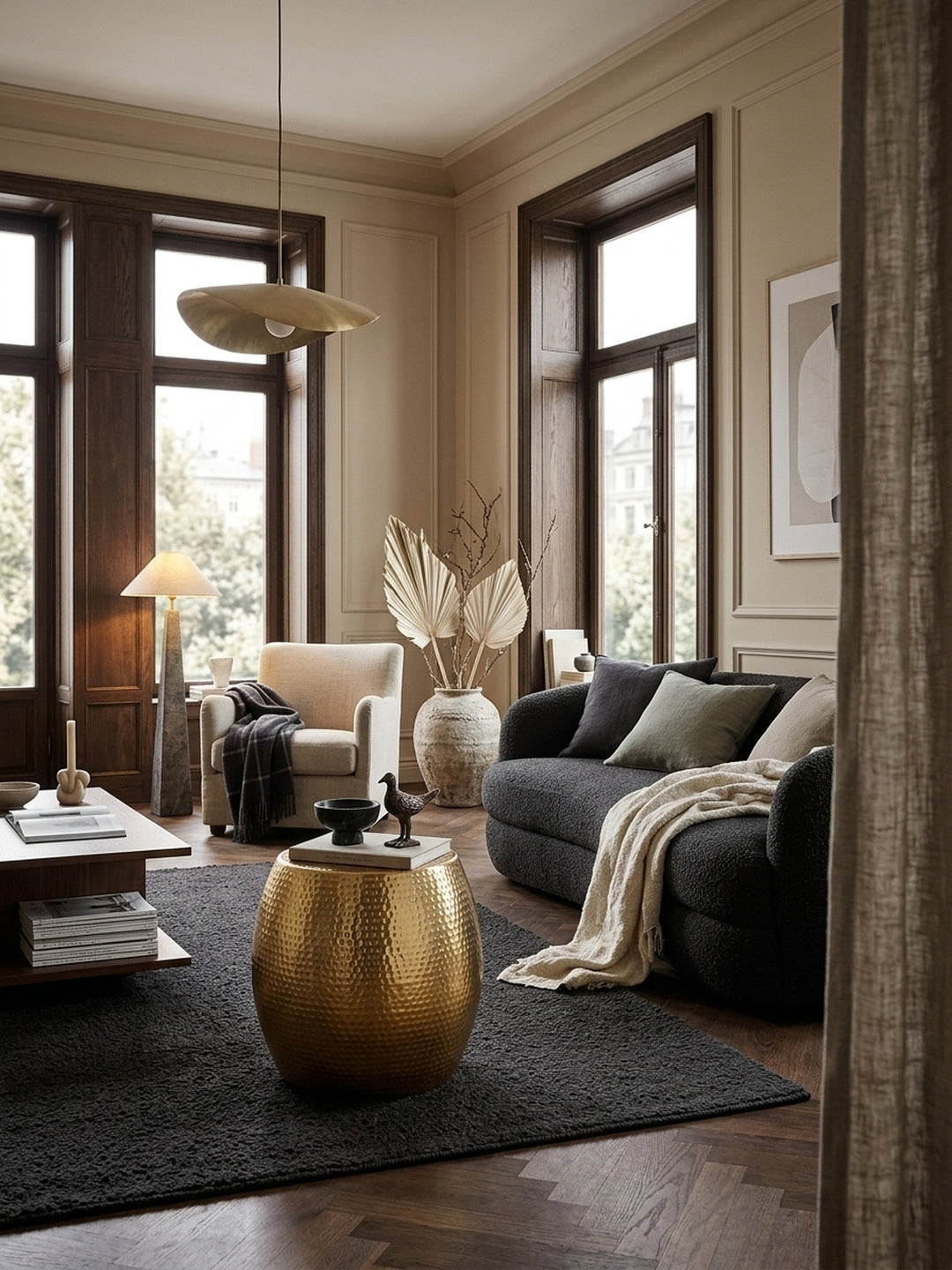 Eleganter runder Beistelltisch aus goldfarbenem Aluminium im stilvollen Wohnzimmer. Die glänzende Hammerschlag-Optik setzt warme Akzente neben einem hellen Leinensofa._