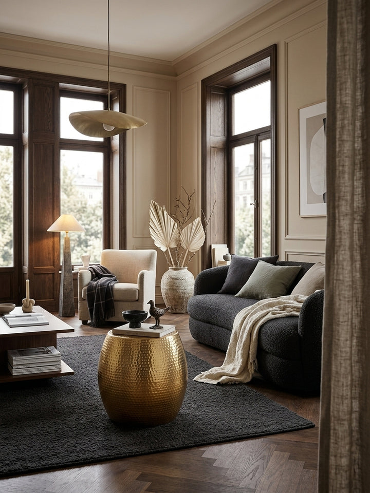 Eleganter runder Beistelltisch aus goldfarbenem Aluminium im stilvollen Wohnzimmer. Die glänzende Hammerschlag-Optik setzt warme Akzente neben einem hellen Leinensofa._