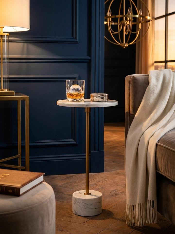 Stilvoller Anstelltisch aus weißem Marmor und Gold, dekoriert mit einem schwarzen Kerzenglas und einem Raumduft-Diffusor._