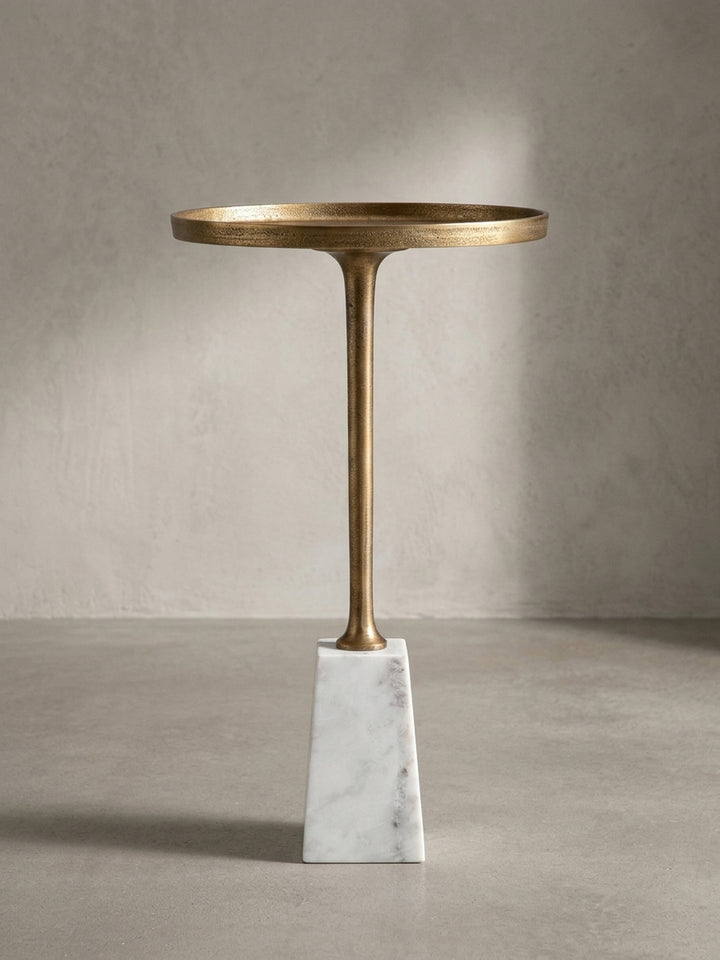 Detailaufnahme des Übergangs vom schlanken, goldenen Tischbein zum schweren, präzise gefertigten Sockel aus echtem Marmor._