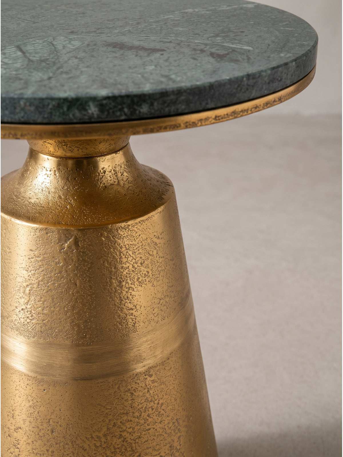 Exklusiver Anstelltisch für das Wohnzimmer mit luxuriöser Materialkombination aus kühlem Stein und warmem Metall.