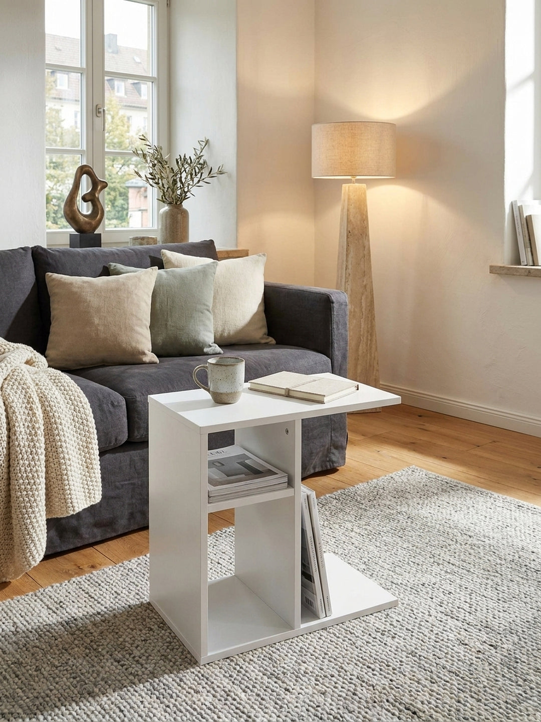 Eleganter weißer C-Form Beistelltisch 50x30x50 cm aus folierter Spanplatte an einem gemütlichen Leinensofa im hellen skandinavischen Wohnzimmer._