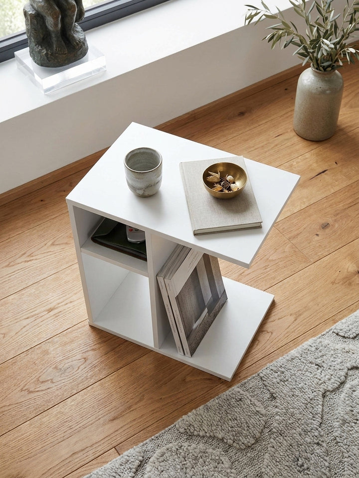 Draufsicht auf den minimalistischen Anstelltisch mit Melaminbeschichtung neben einer modernen Couch auf handgeölten breiten Eichendielen._