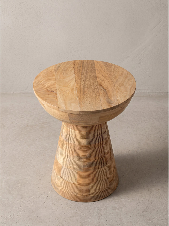 Leicht seitliche Perspektive auf den Massivholz Beistelltisch aus hellem Mangoholz, die sanft geschwungene Schalenform der 37 cm breiten Tischplatte ist deutlich erkennbar_