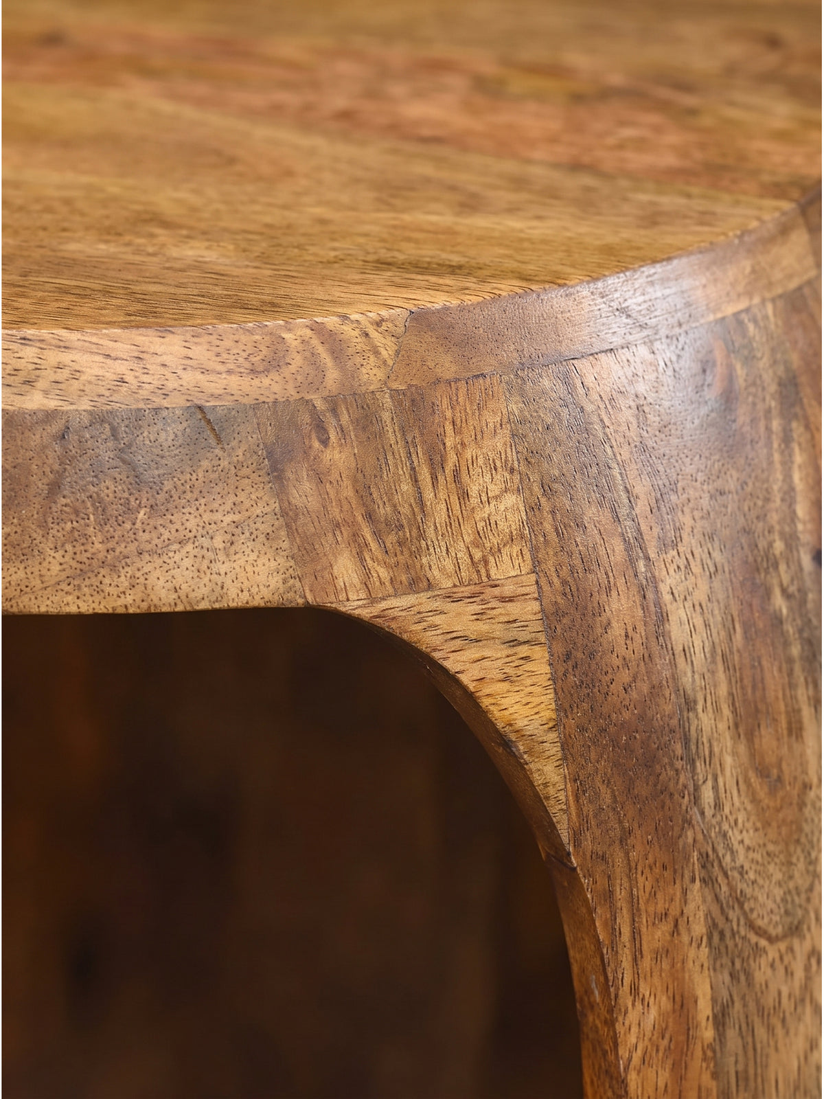 Lebendige Holzmaserung und warmer Farbton der lackierten Oberfläche des massiven Holztisches in extremer Nahaufnahme