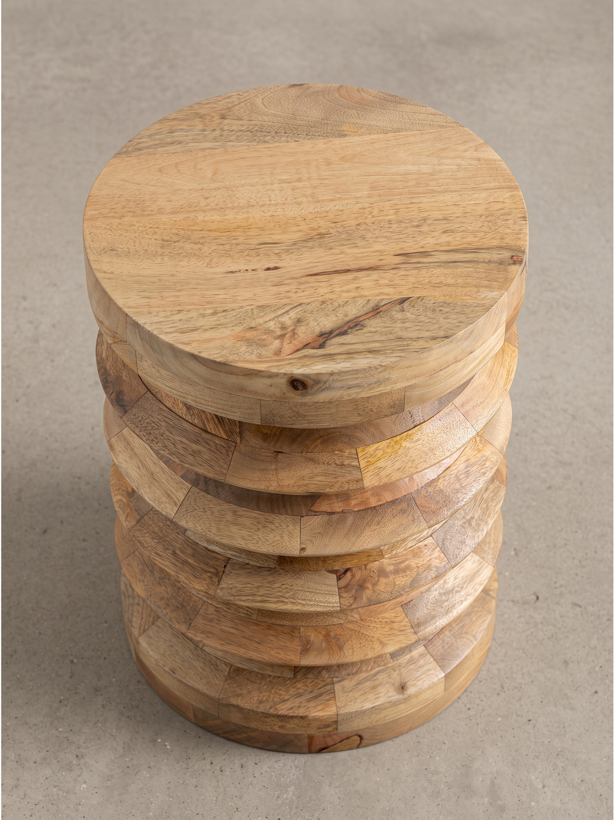 Leicht schräge Perspektive des runden Abstelltisches aus hellem Holz, die die präzise handwerkliche Verarbeitung der markanten Rundungen hervorhebt._