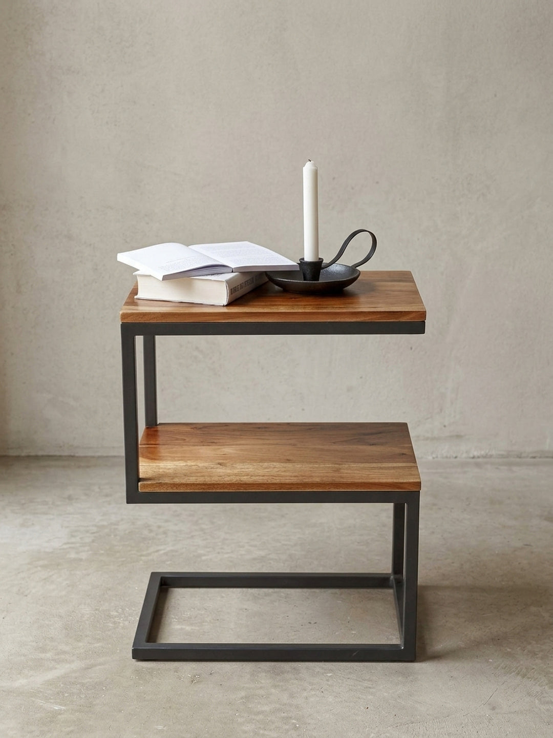 Makro-Fokus auf die Materialübergänge des Anstelltisches. Die glatte, versiegelte Sheeshamholz-Oberfläche trifft bündig auf die präzisen Schweißnähte des matten Stahlgestells._