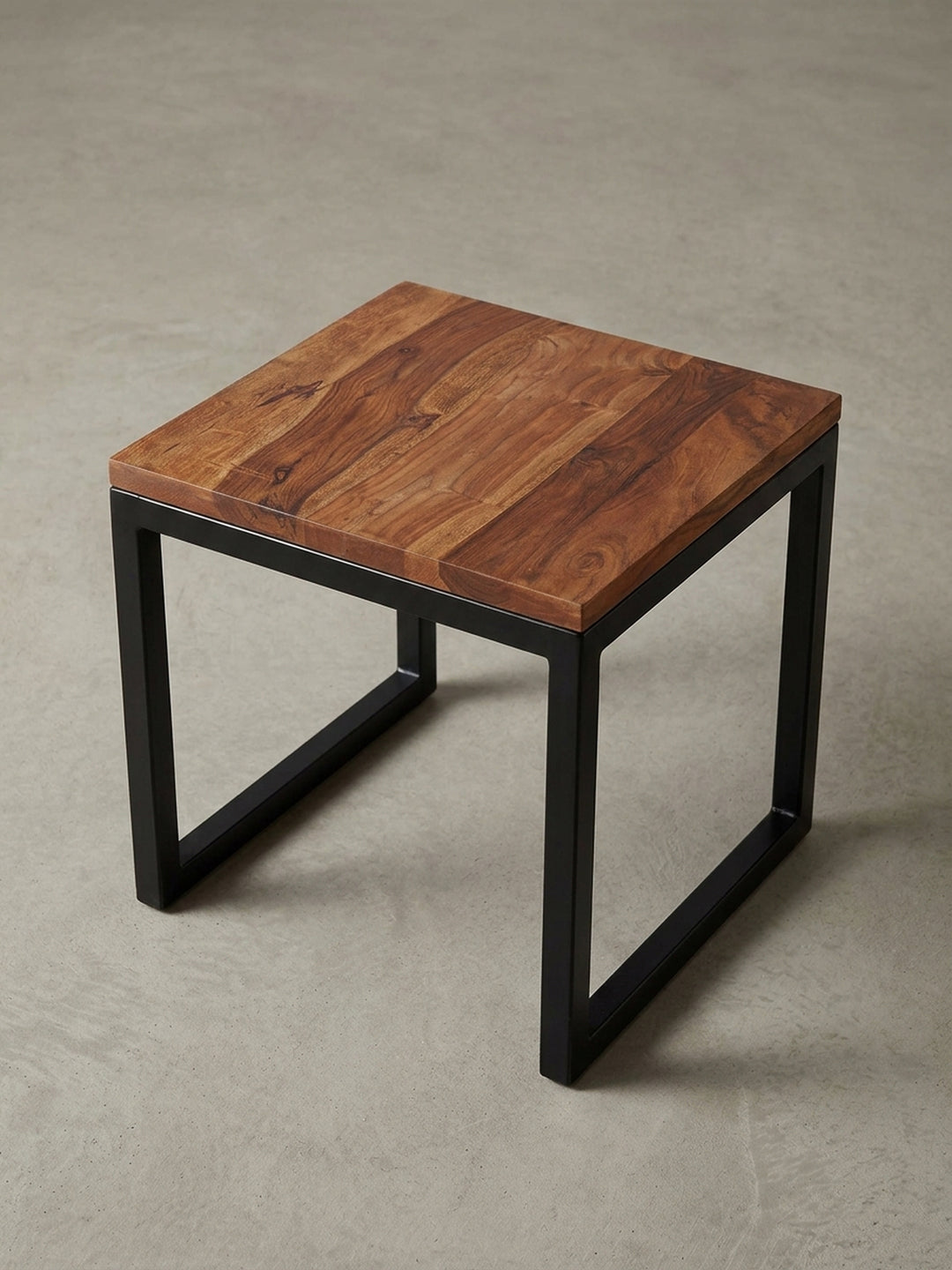 Alternativer Blickwinkel auf den massiven Beistelltisch, der das Zusammenspiel von der warmen Holzoberfläche und dem kühlen, minimalistischen Metallgestell betont._