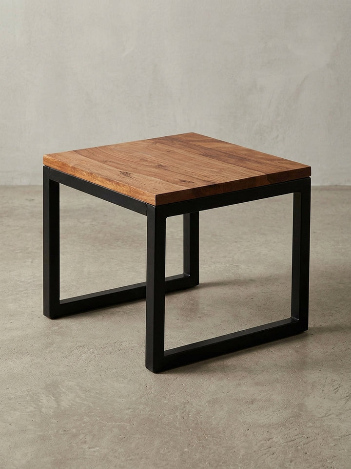 Designer Holztisch in 3/4-Ansicht, die die robuste Konstruktion aus Massivholz und dem pulverbeschichteten Stahlgestell zeigt, ideal als kleiner Couchtisch._