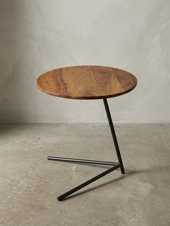 Nahaufnahme der Materialübergänge am Couchtisch. Die schwarze Lackierung des Eisens schützt das Gestell dieses hochwertigen Sheeshamholz Beistelltisches im Industrial Design optimal._