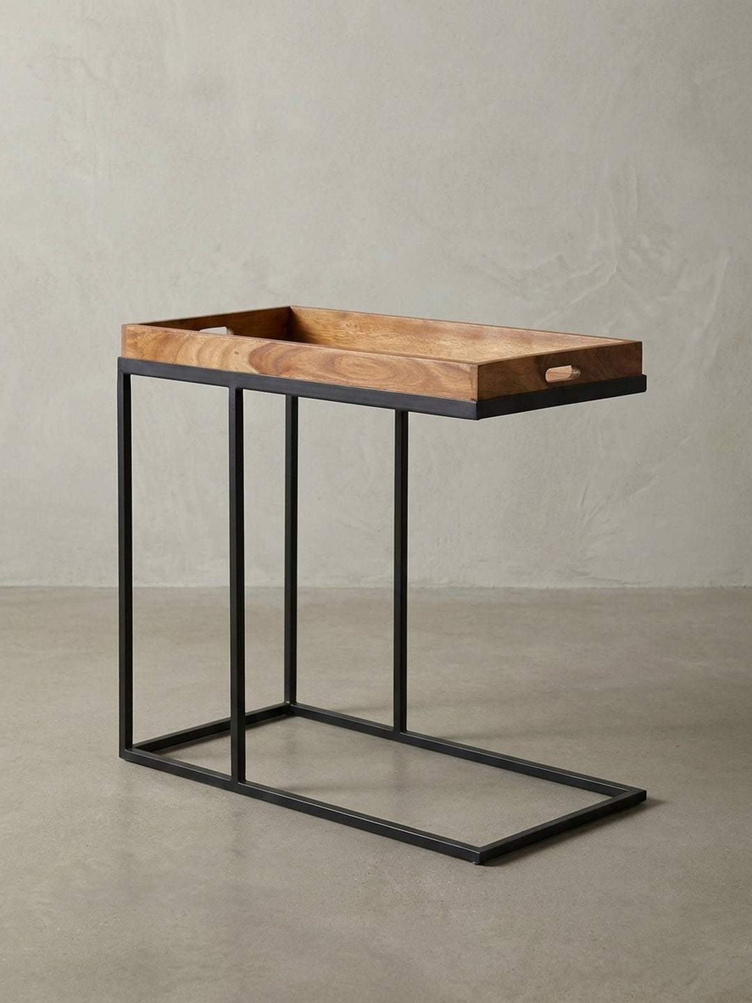 Moderner C-Tisch aus Naturholz und Metall in der Frontalansicht. Der praktische Beistelltisch zeigt seine markante Tablett-Form mit integrierten Griffmulden und schwarzem Gestell._