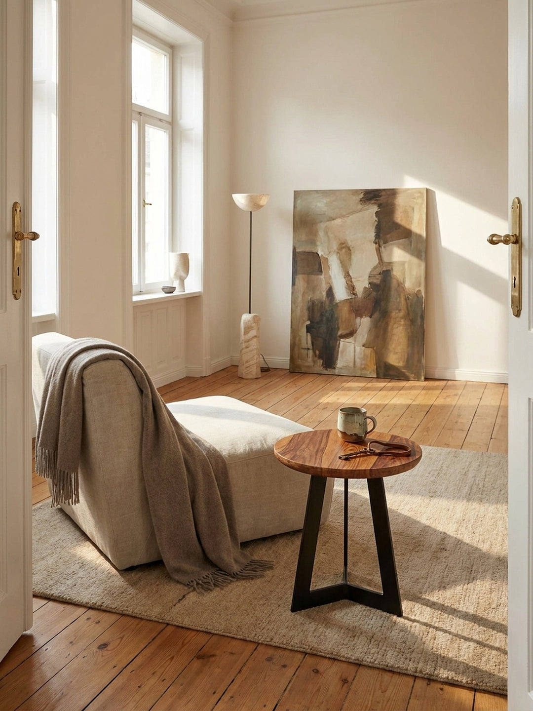 Kleiner Beistelltisch aus Sheesham Massivholz mit schwarzem Metallgestell im hellen Wohnzimmer auf Eichenparkett neben einem tiefen Leinensofa._