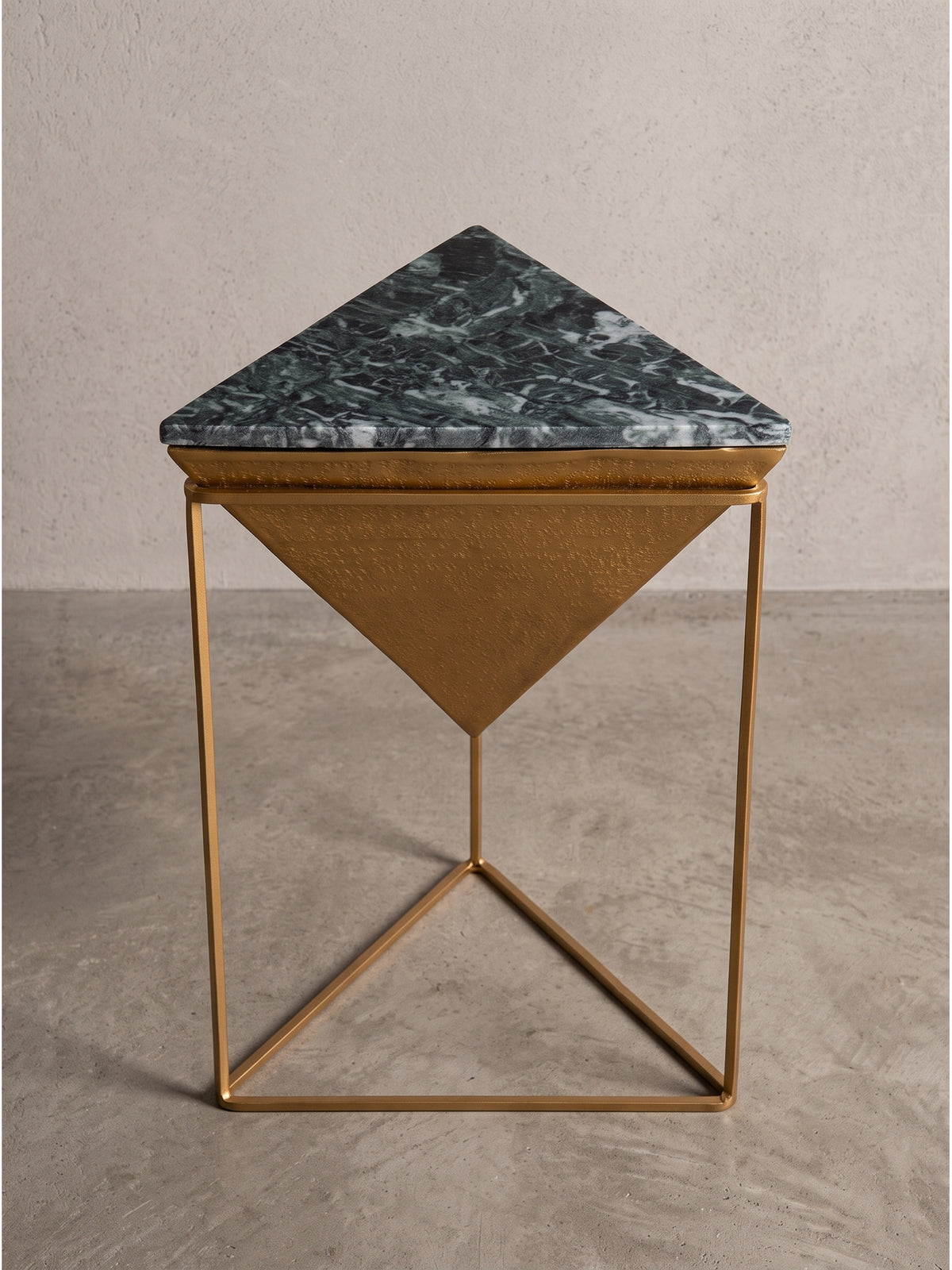 Geometrischer Beistelltisch aus schwarzem Marmor mit auffälligem goldenem Metallgestell in umgedrehter Dreiecksform von der Seite.