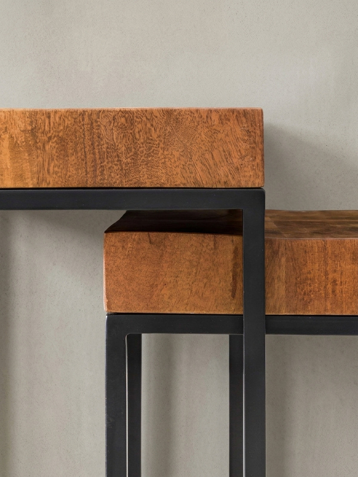 Gesamtübersicht der zwei ineinandergeschobenen Massivholz Beistelltische. Das minimalistische Industrie-Design des Wohnzimmertisches wirkt durch die Naturholz-Maserung besonders exklusiv._