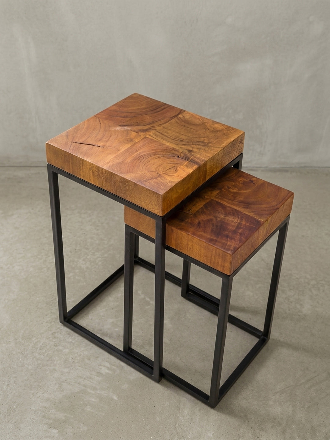 Fokus auf die Materialverbindung beim Satztisch: Das klare, geradlinige Metallgestell umfasst die 6cm dicke Platte aus Sheesham Echtholz, veredelt mit schützendem Klarlack gegen Flecken._