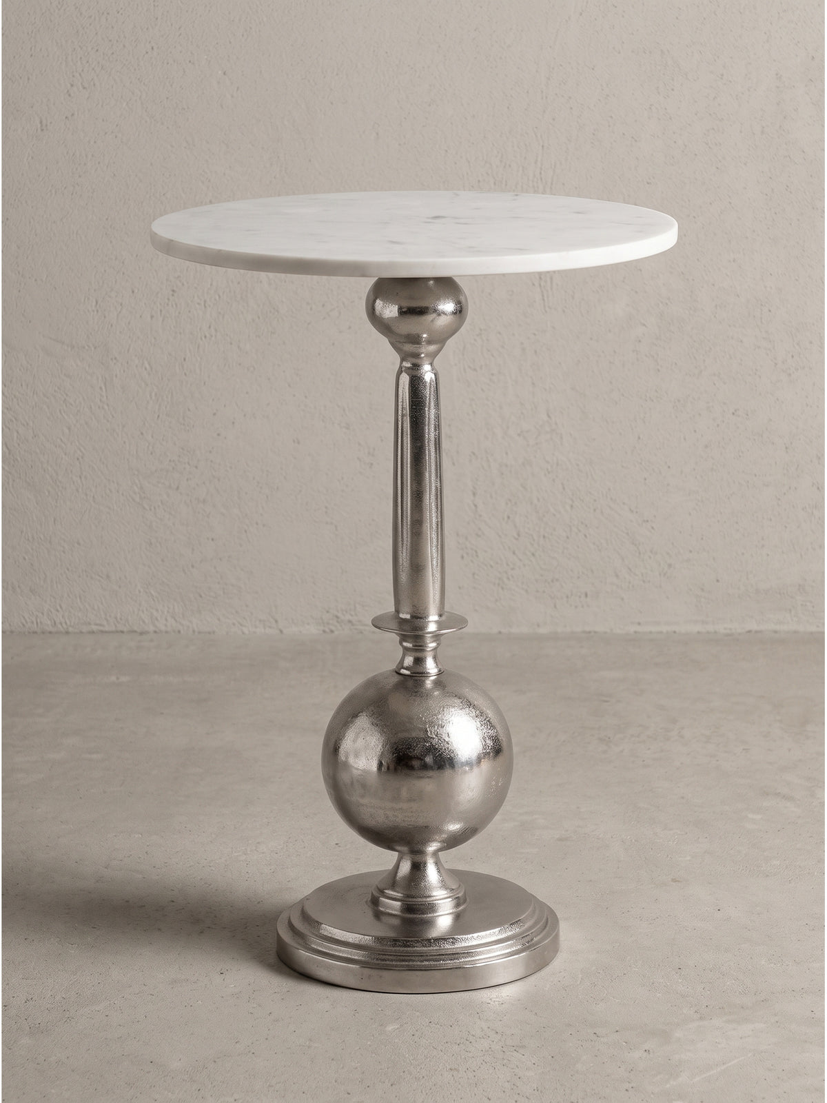 Detailansicht der Verbindung zwischen der weißen Marmorplatte und dem silberfarbenen Aluminium-Standfuß des Design-Tisches