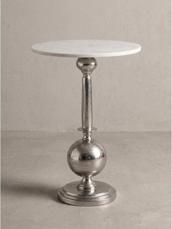 Detailansicht der Verbindung zwischen der weißen Marmorplatte und dem silberfarbenen Aluminium-Standfuß des Design-Tisches_