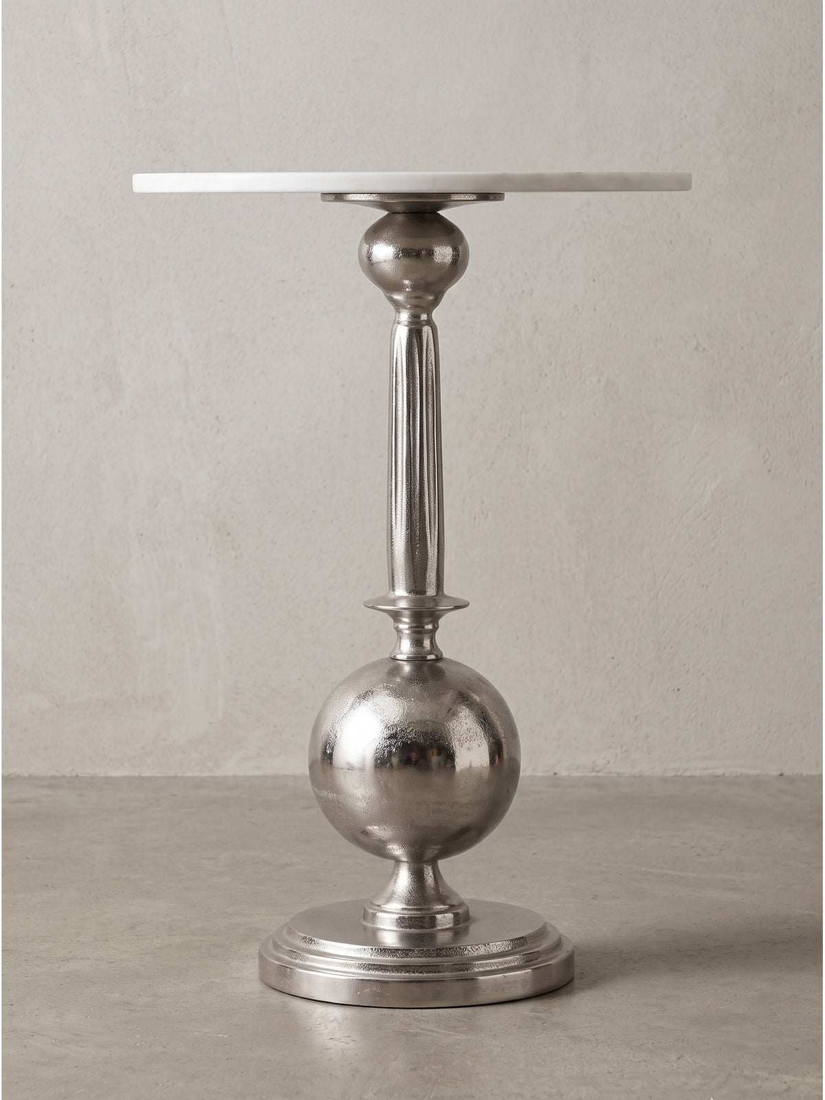 Skulpturaler runder Wohnzimmertisch 57 cm hoch mit aufwendig gestaltetem Standfuß aus Aluminium im Seitenprofil_