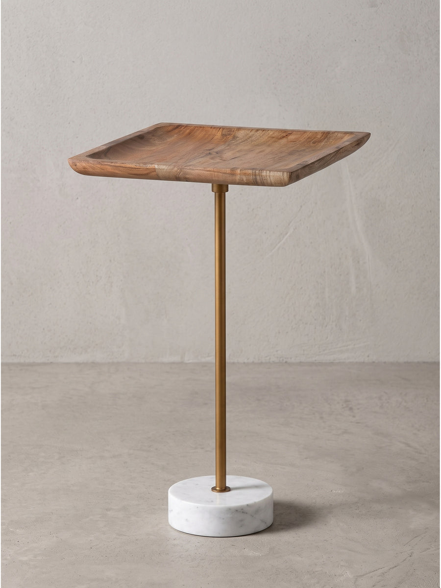 Quadratischer Beistelltisch aus massivem Mangoholz mit goldfarbenem Metallgestell und zylindrischem weißem Marmorsockel in der Frontalansicht._