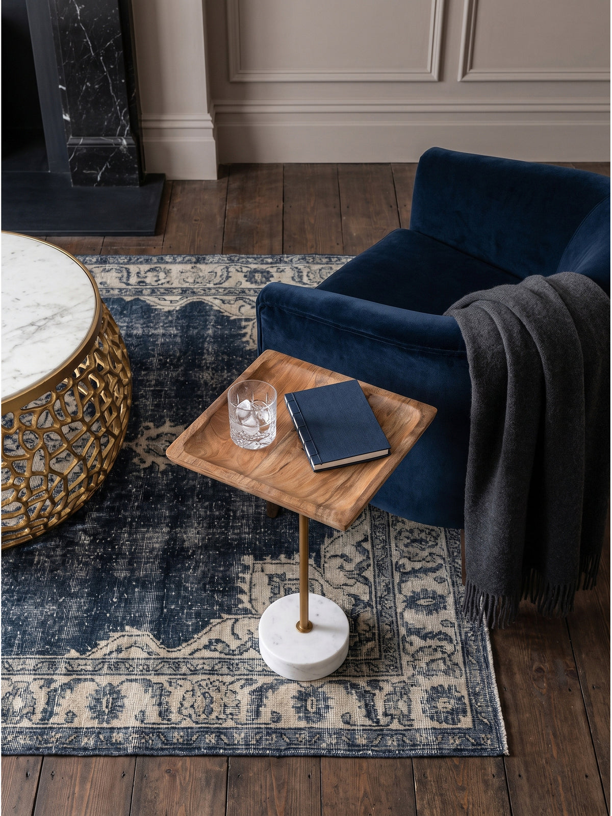 Quadratischer Couchtisch 35x35 cm von oben betrachtet auf einem edlen nachtblauen Wollteppich neben einem komfortablen Lounge-Sessel platziert._