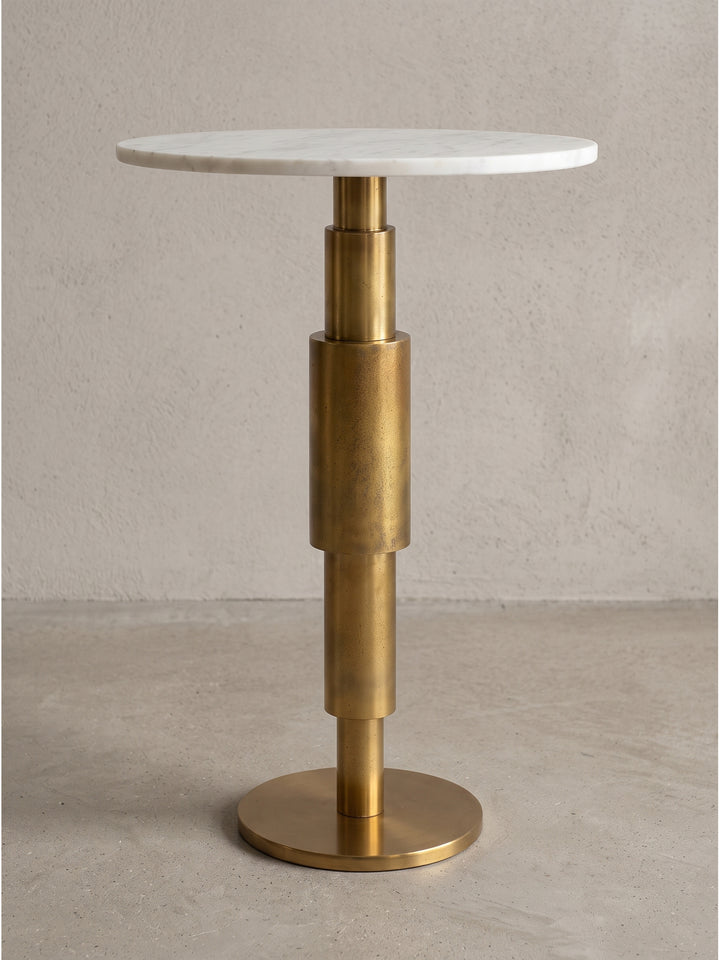 Freigestellter Beistelltisch mit runder weißer Marmorplatte und säulenartigem Aluminiumgestell in eleganter Goldoptik in der Frontalansicht_