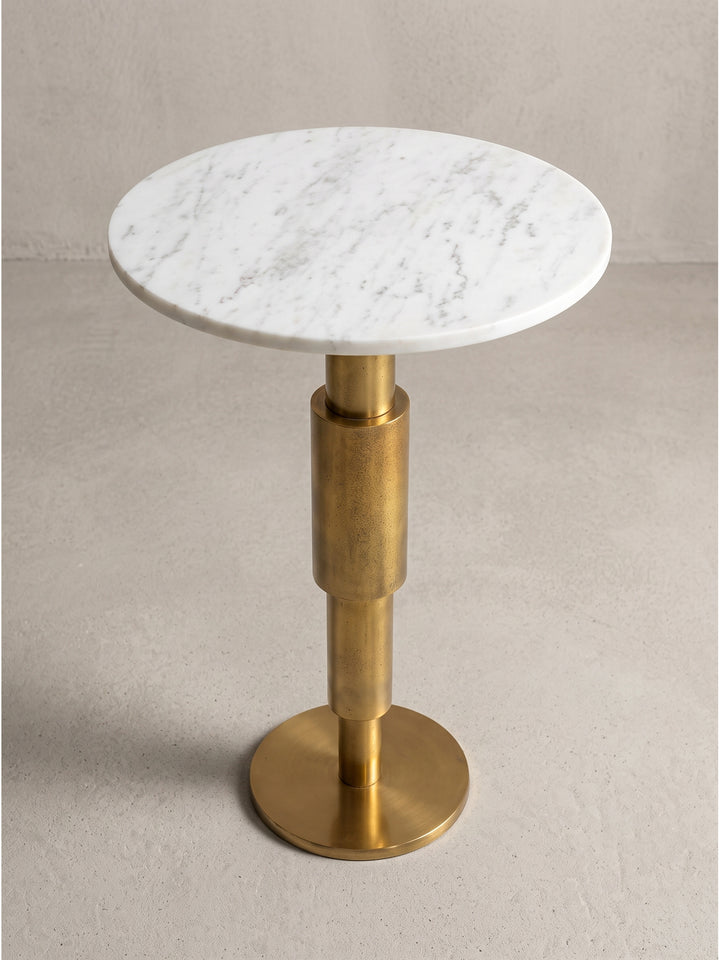 Runder Dekotisch 37x37x59 cm mit skulpturalem Metallfuß und heller Steinoberfläche fotografiert im Studio aus leicht erhöhter seitlicher Perspektive_