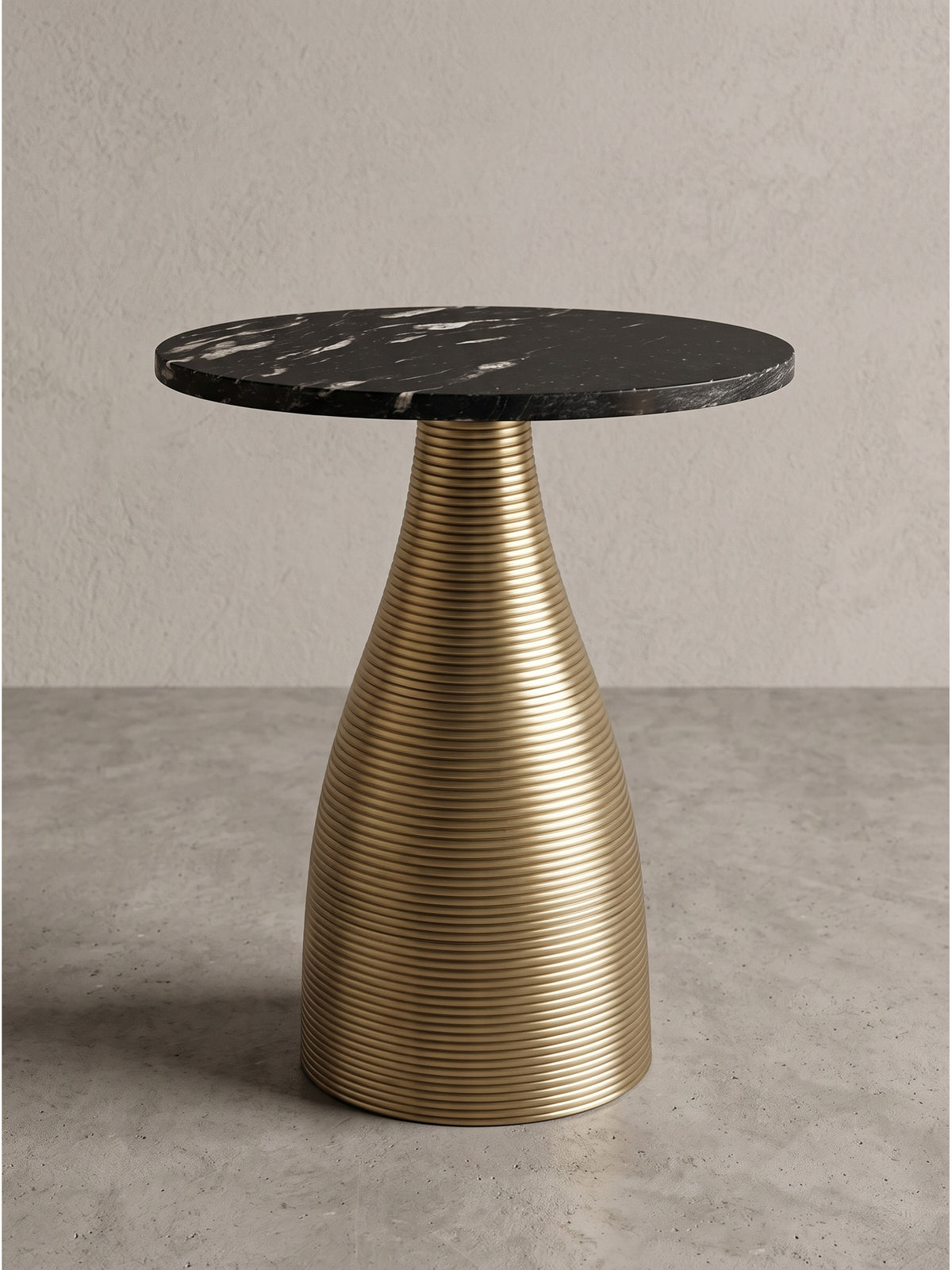 Skulpturaler Beistelltisch 40x48 cm mit runder, massiver Platte aus schwarzem Marmor und einem konischen Metallgestell in Gold-Optik, freigestellt vor einem neutralen Hintergrund._