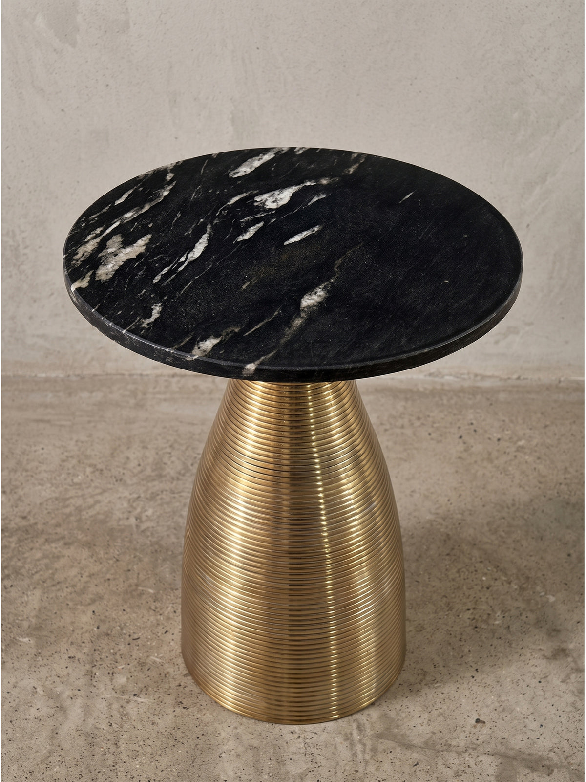 Design-Wohnzimmertisch aus echtem Naturstein und goldfarbenem Aluminiumgestell in der Dreiviertelansicht, die die elegante Silhouette und die harmonischen Proportionen des Möbels zeigt._