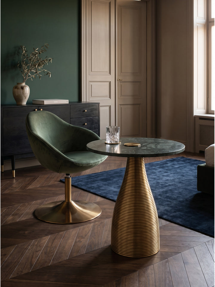 Design Anstelltisch aus Metall und Marmor arrangiert mit einem dunkelgrauen Sessel auf dunklem Nussholzparkett_