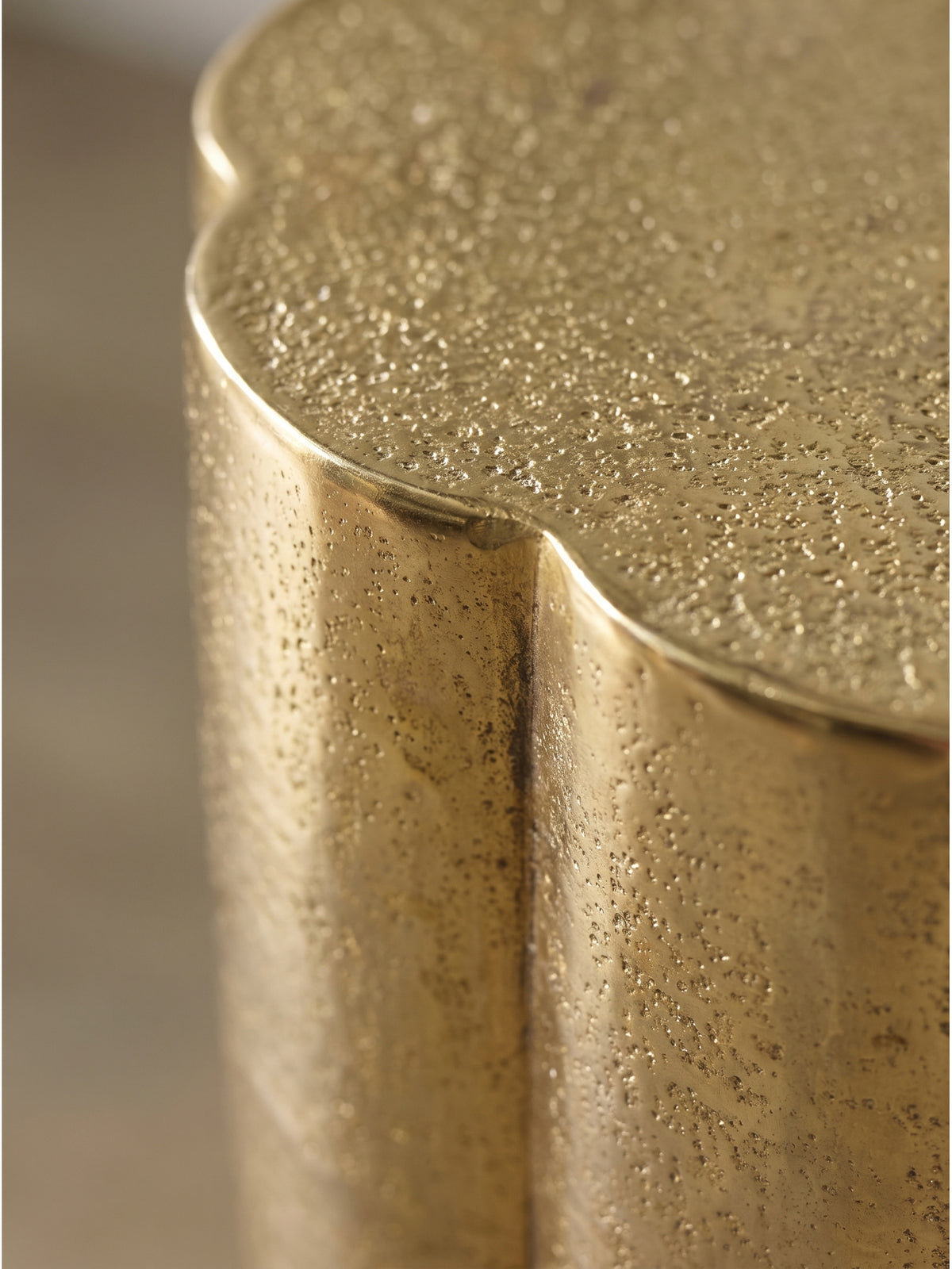 Nahaufnahme der strukturierten goldenen Oberfläche des Aluminiumtisches mit handgefertigtem Charakter