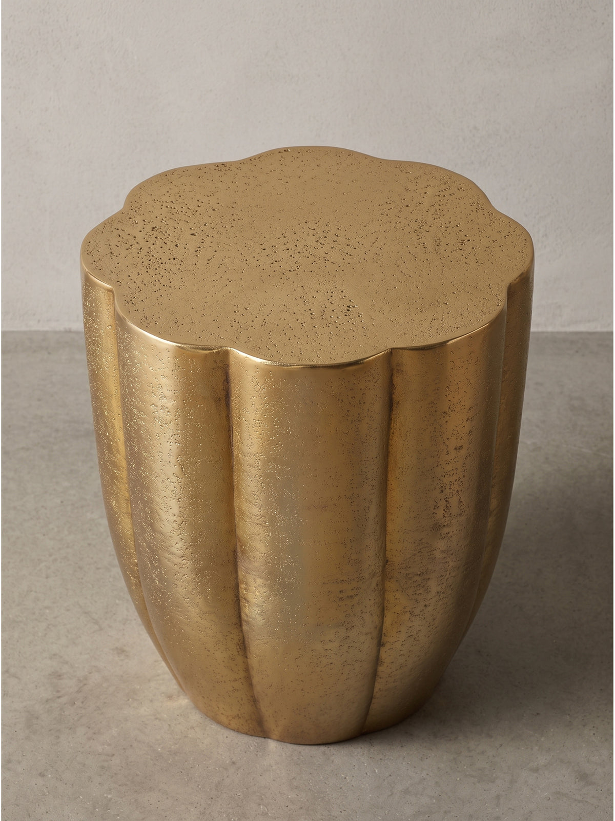 Design Couchtisch klein aus Metall in Gold leicht schräg von der Seite im Studio fotografiert_
