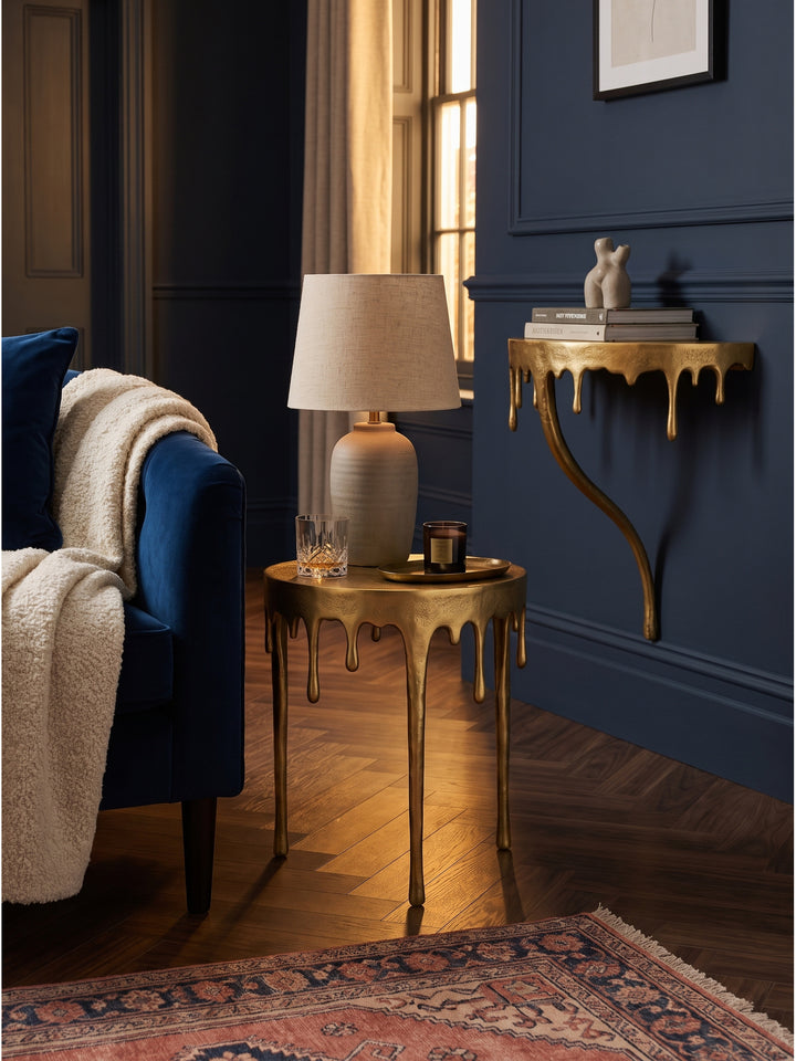 Goldener Beistelltisch mit Kaffeetasse und Büchern dekoriert im modernen Wohnzimmer neben hellem Leinensofa_