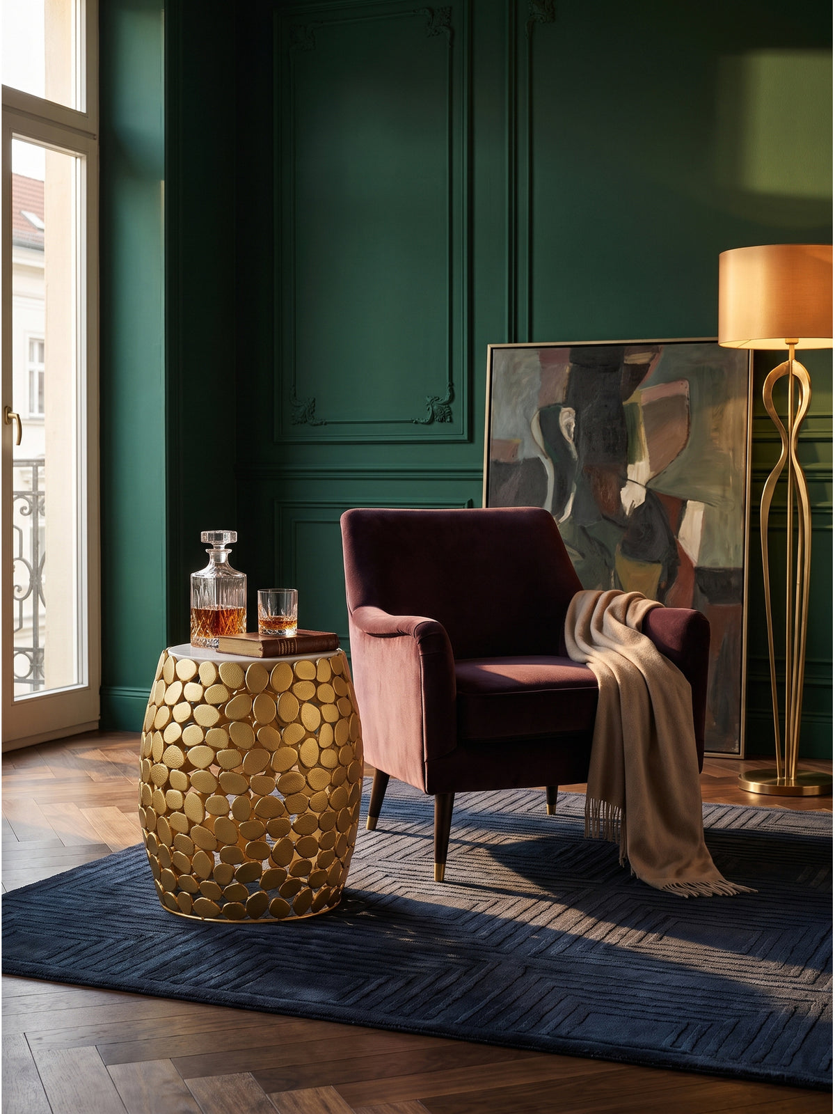 Der extravagante Deko-Tisch aus Alu und Marmor harmoniert als skulpturaler Akzent perfekt mit dem schweren Samt-Sofa und der klassischen Messing-Stehleuchte._