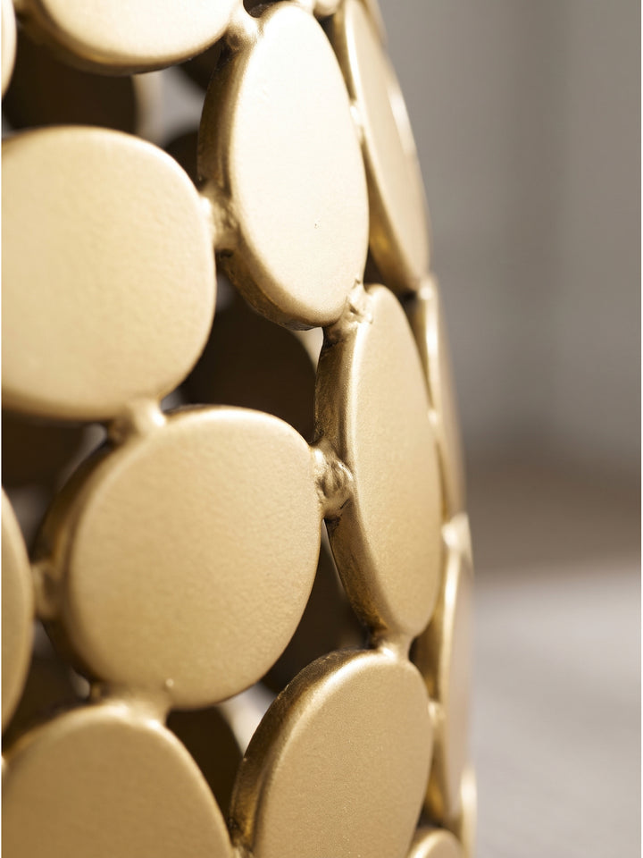 Nahaufnahme der organisch geformten goldenen Aluminium-Elemente und der durchbrochenen Struktur des Design-Beistelltisches._