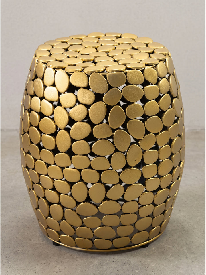 Makro-Detail der goldenen Pulverbeschichtung und der asymmetrischen Kieselstein-Ausschnitte des Metalltisches._