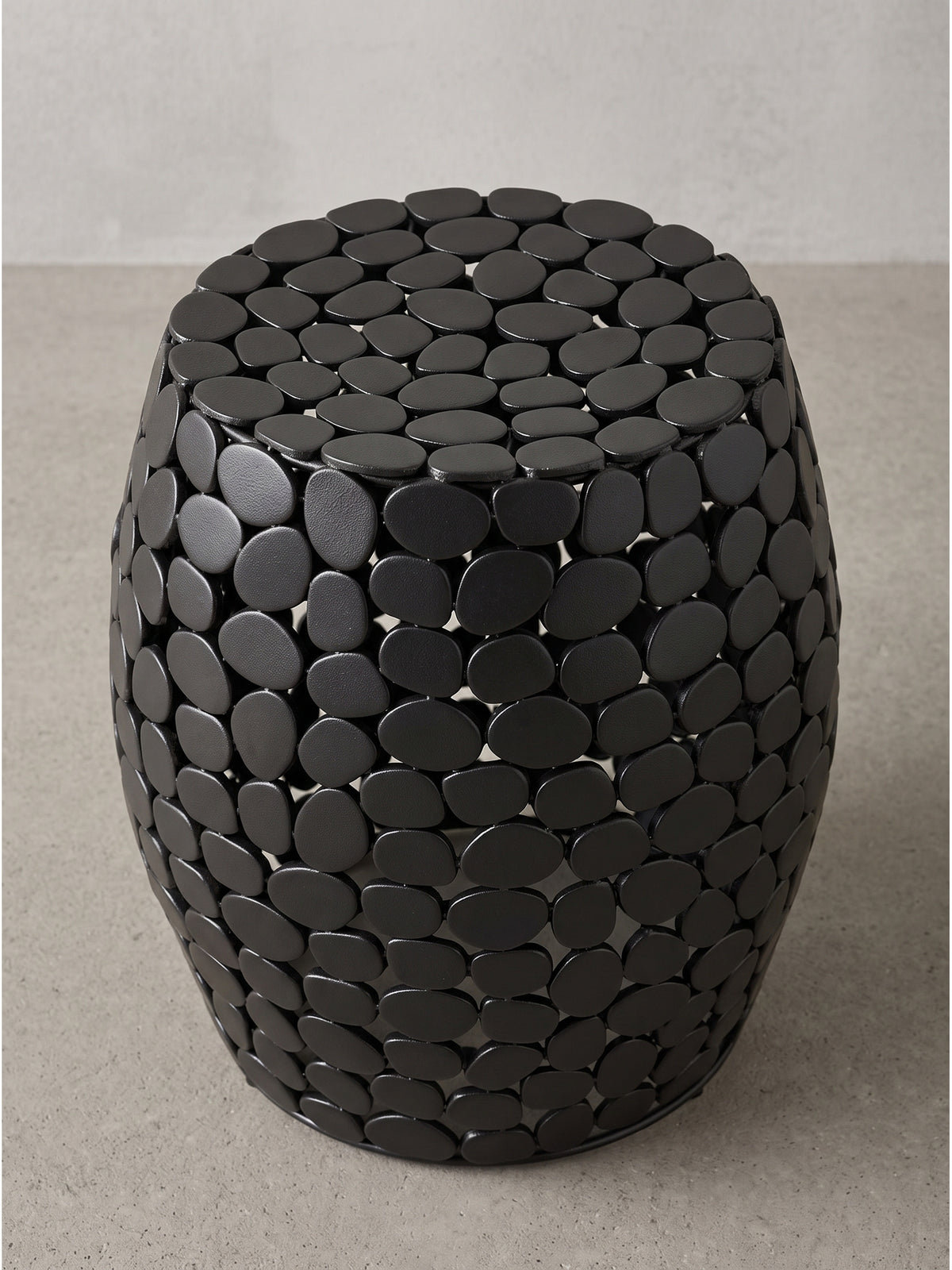 Leichter Couchtisch aus schwarzem Aluminium mit durchbrochener Kiesel-Optik aus leicht seitlicher Perspektive_