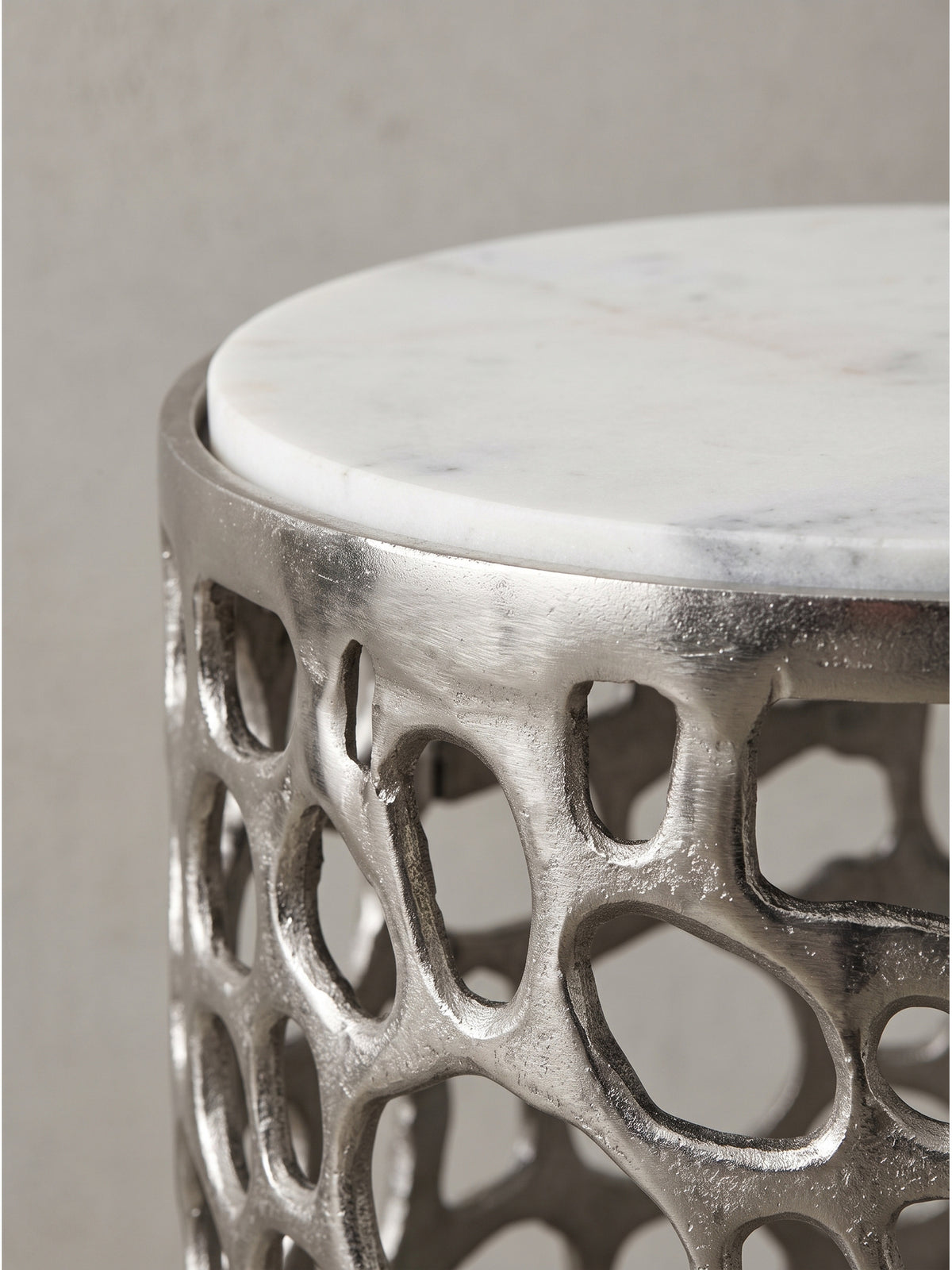 Runder Designertisch aus Aluminium und Marmor aus leicht erhöhter Perspektive für stilvolles Interieur_
