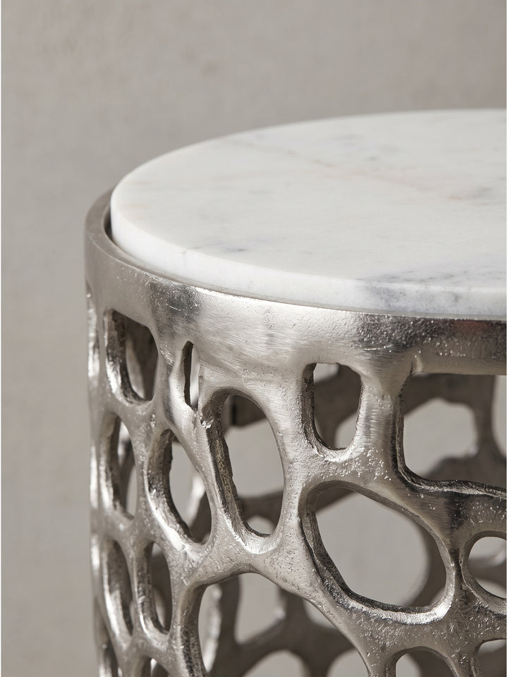 Runder Designertisch aus Aluminium und Marmor aus leicht erhöhter Perspektive für stilvolles Interieur_