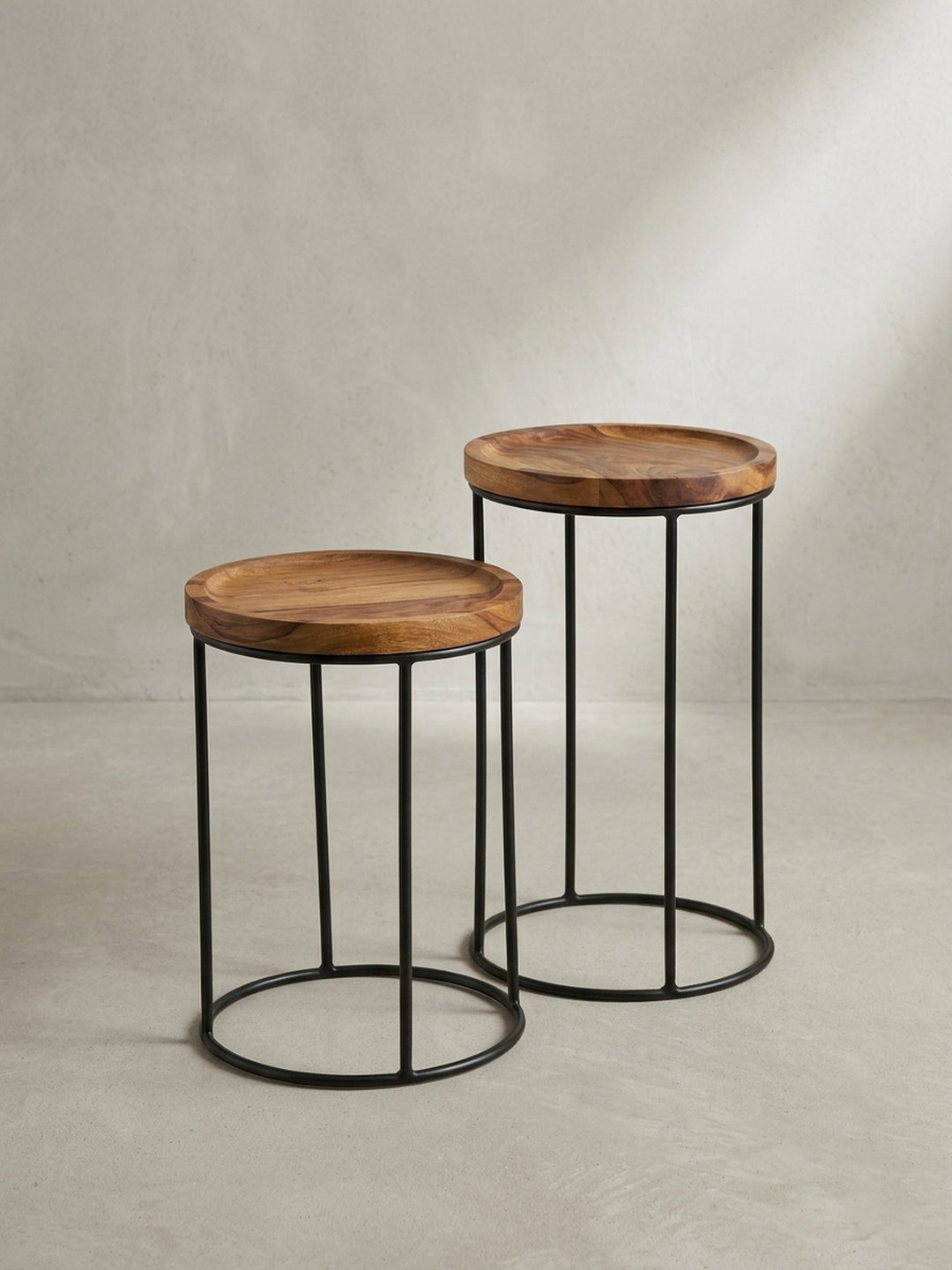 Schrägansicht der ineinanderschiebbaren Holztische im Industrial Style mit umlaufendem Rand und pulverbeschichtetem Metallgestell._