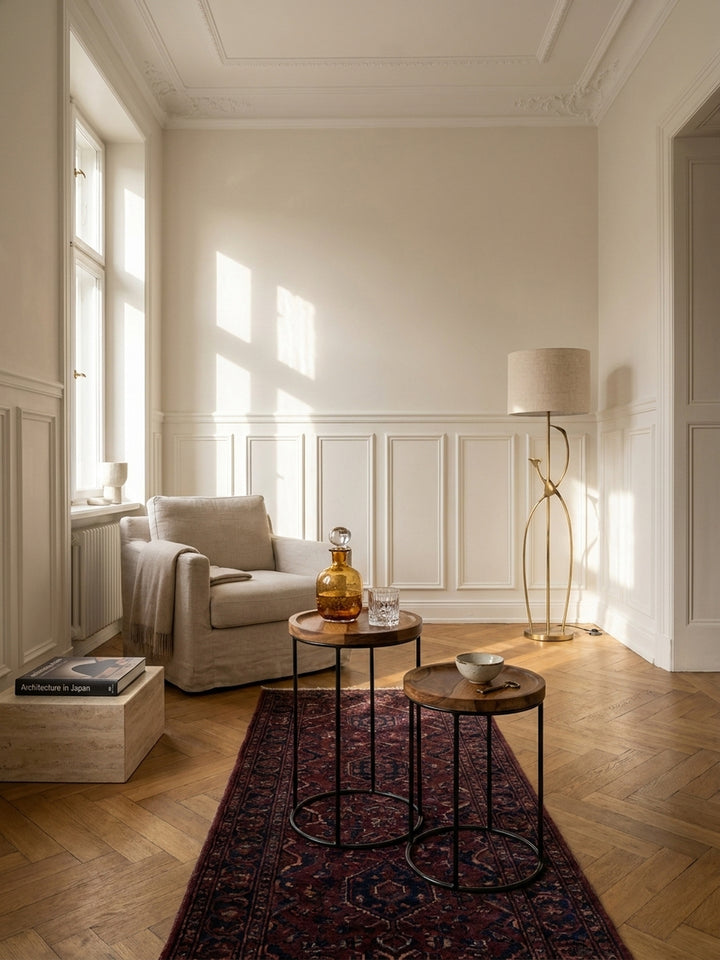 Elegantes Beistelltisch Set aus massivem Sheeshamholz im luxuriösen Wohnzimmer auf verblasstem Perserteppich neben einem hellen Leinen-Sessel._