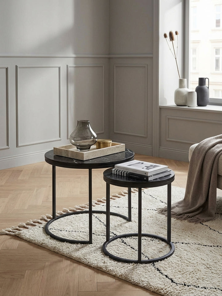 Modernes Beistelltisch-Set in einem hellen Wohnzimmer, platziert neben einem grauen Sofa auf einem beigen Teppich. Die schwarze Marmor-Optik setzt einen eleganten Akzent._
