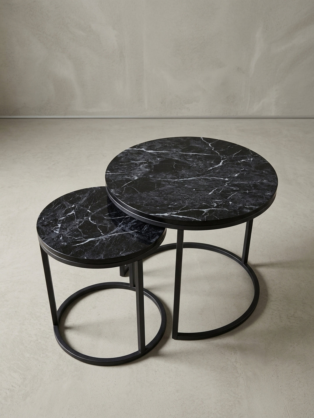 Detailaufnahme des schwarzen Metallgestells eines runden Beistelltisches. Die sandgestrahlte, matte Oberfläche des Stahls unterstreicht den modernen Industrie-Look._