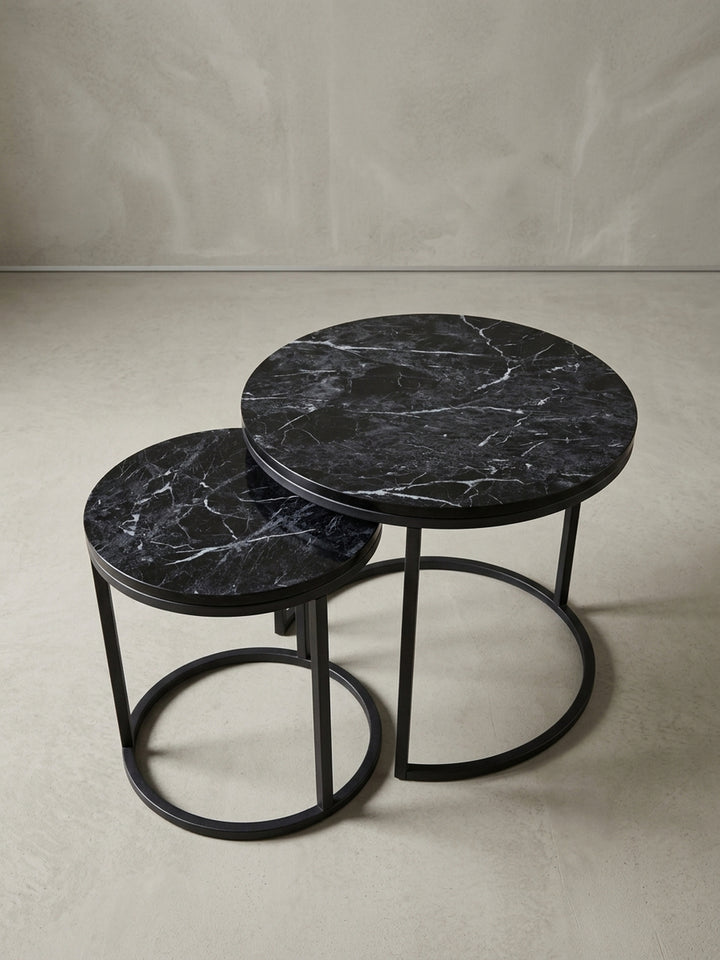 Detailaufnahme des schwarzen Metallgestells eines runden Beistelltisches. Die sandgestrahlte, matte Oberfläche des Stahls unterstreicht den modernen Industrie-Look._